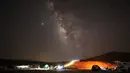Meteor Perseid melintas di langit di atas lokasi perkemahan di gurun Negev dekat kota Mitzpe Ramon, Israel pada 11 Agustus 2020. Hujan meteor ini terjadi setiap tahun sekitar bulan Agustus, saat Bumi melayang melalui awan yang ditinggalkan oleh komet raksasa 109P / Swift-Tuttle. (MENAHEM KAHANA/AFP)