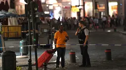 Polisi berbincang dengan salah satu calon penumpang usai terjadi ledakan di sebuah jalan di luar Gare Centrale di Brussels, Belgia (20/6). Dalam peristiwa ini tidak ada korban jiwa. (AFP Photo/Emmanuel Dunand)