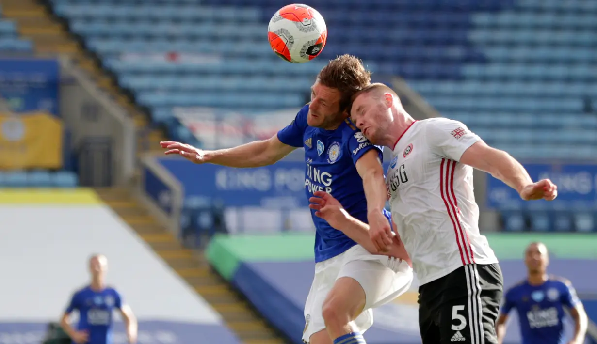 Penyerang Leicester City, Jamie Vardy melompat saat berebut bola dengan pemain Sheffield United, Jack O'Connell dalam lanjutan Liga Inggris pekan ke-36 di Stadion King Power, Kamis (16/7/2020). Leicester City sukses menggulung tamunya, Sheffield United dengan skor 2-0. (David Davies/Pool via AP)