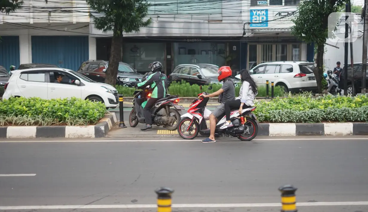 Pengendara sepeda motor menerobos jalur pejalan kaki dan disabilitas di Jalan RS Fatmawati Raya, Cipete, Jakarta, Rabu (8/1/2020). Kurangnya sanksi tegas bagi pengguna kendaraan di jalur pejalan kaki menyebabkan banyak pelanggaran terhadap jalur khusus tersebut. (Liputan6.com/Immanuel Antonius)