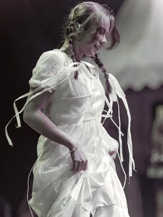 Penampilan sempurna Nadin Amizah mengenakan dress vintage berwarna putih dan rambut dikepang dua. [Foto: Instagram/cakecaine]