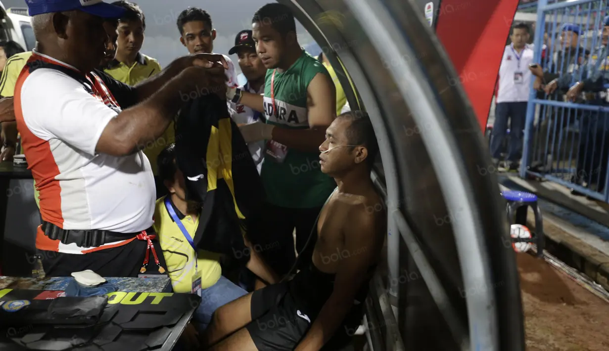 Wasit Oky Dwi Putra Senjaya mengalami sesak napas akibat asap flare memimpin Madura United vs Persiba Balikpapan pada Torabika SC2016 di Stadion Gelora Bangkalan, Senin(13/6/2016).  (Bola.com/Nicklas Hanoatubun)