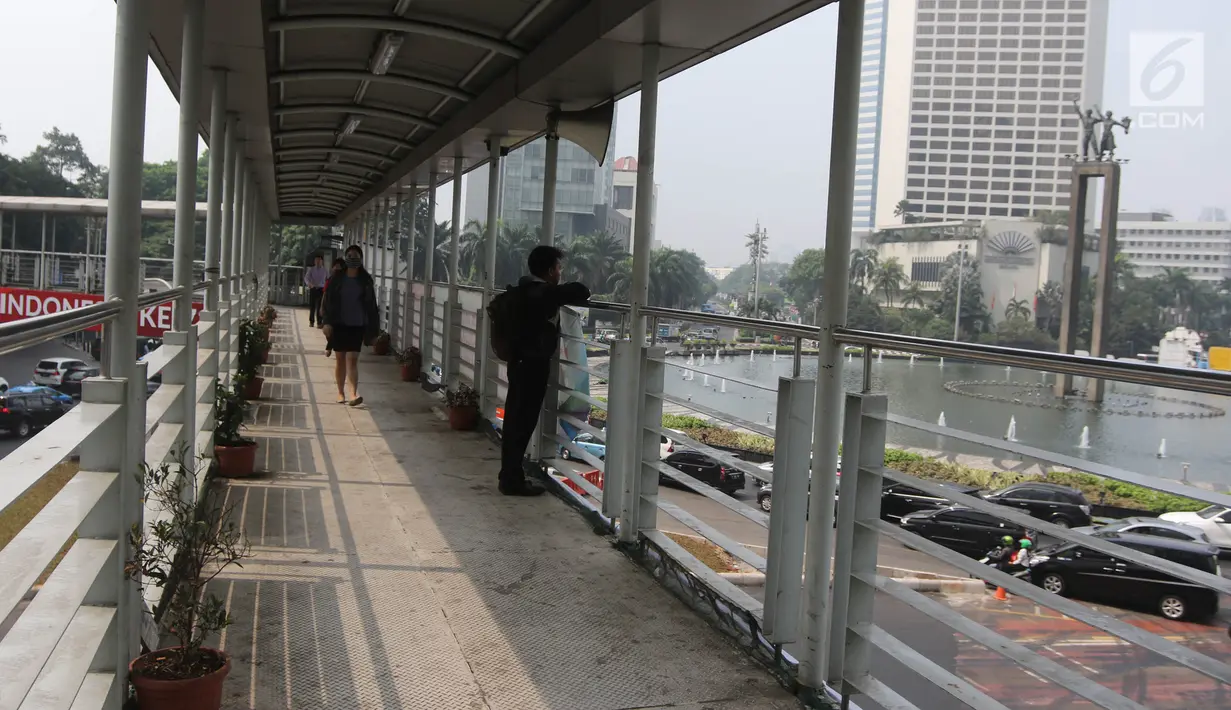 Pejalan kaki melintas di jembatan penyeberangan orang (JPO) di Bundaran HI, Jakarta, Selasa (24/7). Pemprov DKI berencana merobohkan JPO tersebut karena menghalangi pandangan ke Patung Selamat Datang. (Liputan6.com/Arya Manggala)