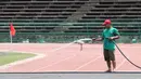 Pekerja menyiram rumput di Stadion National Olympic, Phnom Penh, Rabu (20/2). Stadion ini menjadi salah satu venue yang menggelar laga Piala AFF U-22 2019. (Bola.com/Zulfirdaus Harahap)