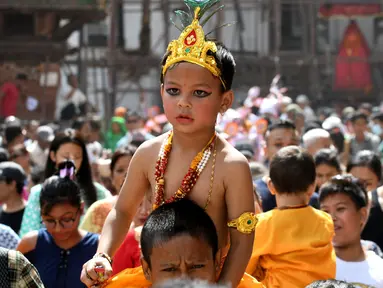 Seorang anak Nepal mengenakan kostum seperti dewa Krishna mengikuti Gai Jatra cow festival di Kathmandu, Nepal (8/8). Festival Gai jatra ini juga disebut festival sapi dan cukup populer di Nepal. (AFP Photo/Prakash Mathema)
