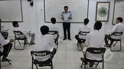 Petugas memberikan pengarahan kepada para narapidana LP Cipinang yang menjalani UN melalui program Paket C di LP Narkotika Cipinang, Jakarta, Senin (13/4/2015).  Para peserta terlihat bersemangat menjalani UN 2015. (Liputan6.com/Johan Tallo)
