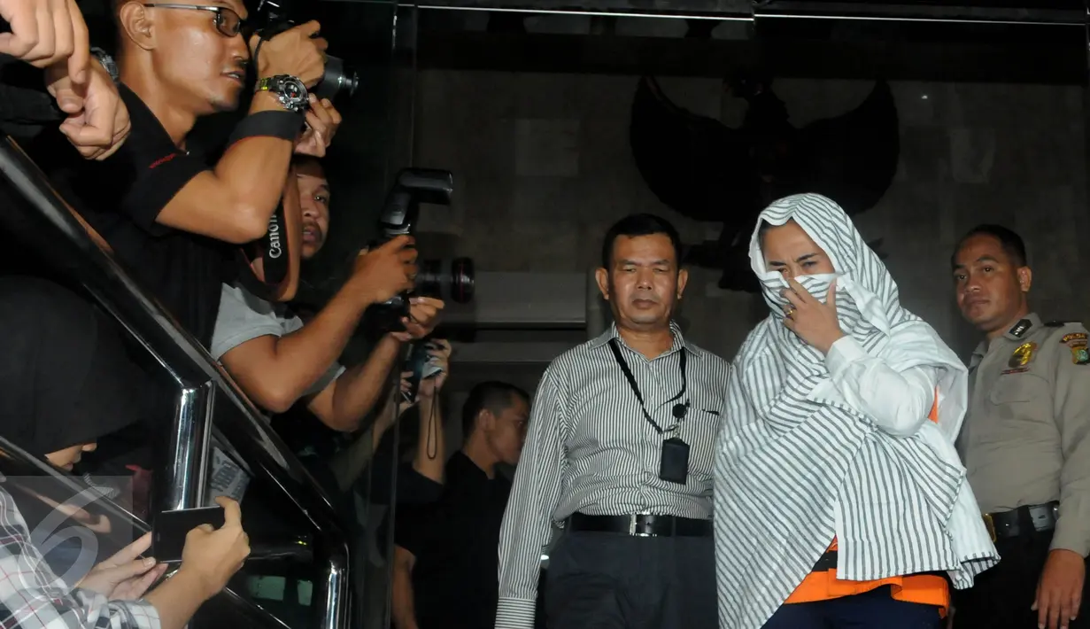 Tersangka kasus dugaan suap terkait rencana proyek pembangunan 12 ruas jalan di Sumatera Barat, Noviyanti selaku sekretaris Komisi III DPR RI, I Putu Sudiartana usai menjalani pemeriksaan di Gedung KPK, Jakarta, Kamis (30/6).(Liputan6.com/Helmi Afandi)
