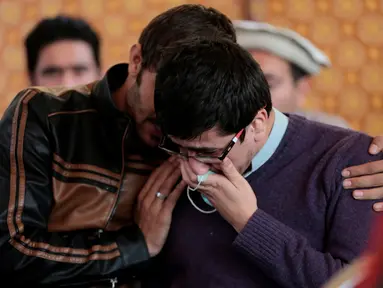 Kerabat dari korban kecelakaan pesawat Pakistan International Airlines (PIA) menangis saat menunggu tes DNA di rumah sakit PIMS di Islamabad, Pakistan, Kamis (8/12). (REUTERS / Caren Firouz)