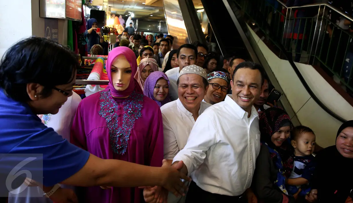 Pedagang berjabat tangan dengan Bakal Calon Gubernur DKI Jakarta Anies Baswedan di Pasar Tanah Abang, Jakarta, Jumat (21/10). Dalam kunjungannya Anies Baswedan menyapa para pengunjung dan pedagang Pasar Tanah Abang. (Liputan6.com/Johan Tallo)