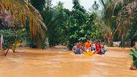 Polisi mengevakuasi korban banjir Kuansing karena luapan sungai dan kiriman dari Sumbar. (Liputan6.com/M Syukur)