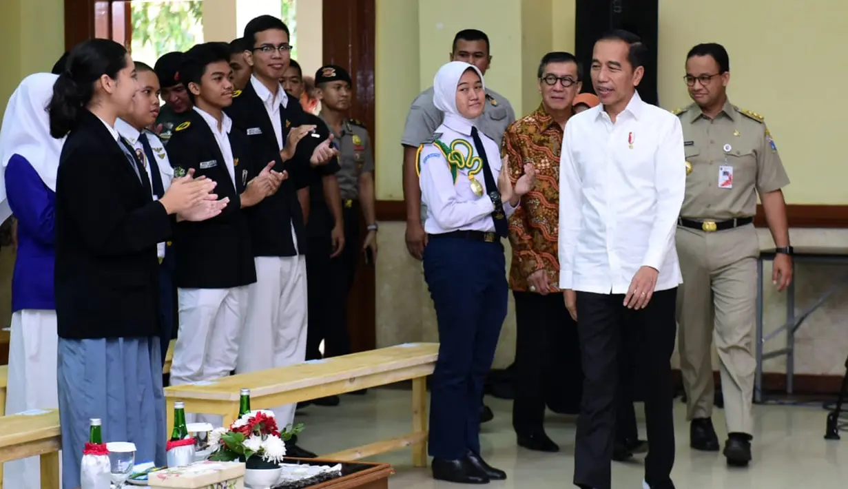 Presiden Joko Widodo (kemeja putih) tiba untuk menyaksikan drama bertajuk Prestasi Tanpa Korupsi di SMKN 57 Jakarta, Jakarta Selatan, Senin (9/12/2019). Kegiatan tersebut dalam rangka memperingati Hari Antikorupsi Sedunia. (Liputan6.com/Biropres Kepresidenan)