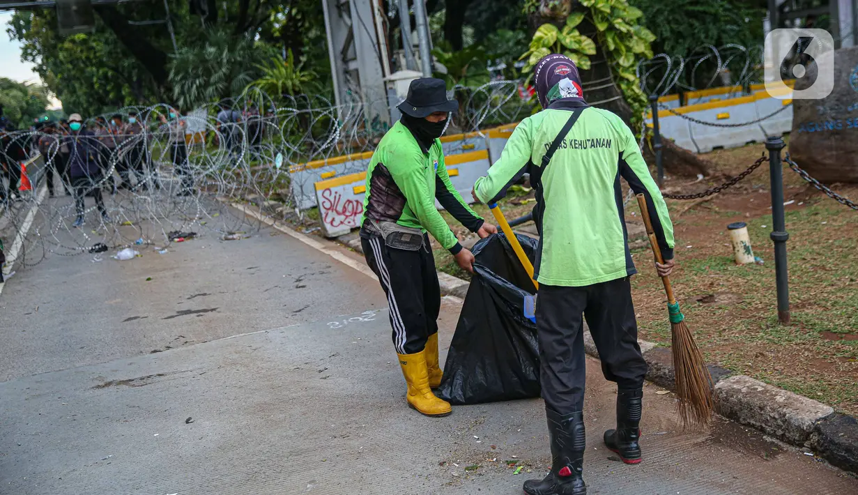 Petugas kebersihan membersihkan sampah sisa pendemo usai unjuk rasa buruh di kawasan Patung Kuda, Jakarta, Kamis (22/10/2020). Sebelumnya, buruh dari berbagai elemen berunjuk rasa menolak pengesahan Omnibus Law UU Cipta Kerja. (Liputan6.com/Faizal Fanani)