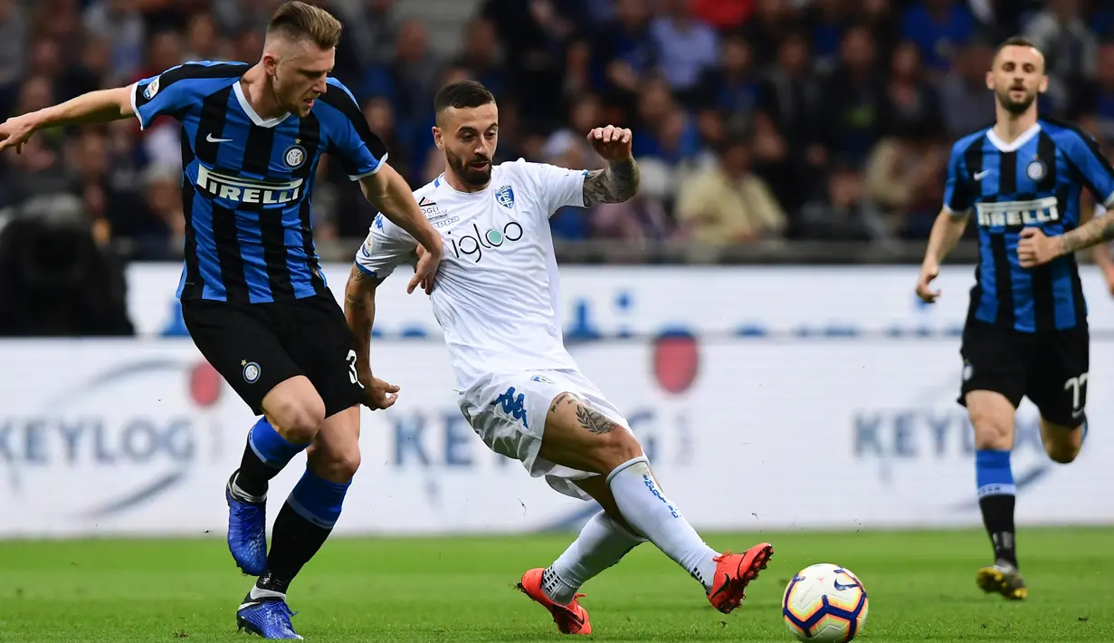 Pemain Empoli, Francesco Caputo berebut bola dengan bek Inter Milan, Skriniar pada pertandingan pekan ke-38 Serie A di Giuseppe Meazza, Minggu (26/5/2019). Inter Milan akhirnya lolos ke Liga Champions musim depan setelah bersusah payah menyegel kemenangan 2-1 atas Empoli. (Miguel MEDINA/AFP)