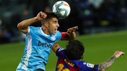 Striker Barcelona, Lionel Messi, duel udara dengan pemain Leganes, Unai Bustinza, pada laga La Liga di Stadion Camp Nou, Selasa (16/6/2020). Barcelona menang 2-0 atas Leganes. (AP Photo/Joan Montfort)