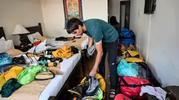 Sebelum memulai pendakia, sejumlah persiapan dilakukan keduanya, baik fisik dan peralatan, termasuk mental. Dalam foto yang diambil pada 31 Agustus 2025 terlihat pendaki gunung Prancis Benjamin Vedrines saat menyortir perlengkapan pendakiannya setelah wawancara dengan AFP di Kathmandu. (Prakash MATHEMA/AFP)