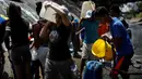 Orang-orang mengumpulkan air yang keluar melalui saluran pembuangan air limbah yang mengalir ke Sungai Guaire di Caracas, 11 Maret 2019. Pemadaman listrik selama berhari-hari di Venezuela berdampak terhadap krisis air. (REUTERS/Carlos Garcia Rawlins)