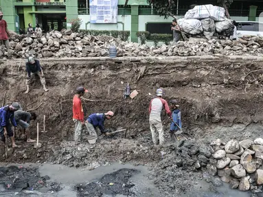 Pekerja Suku Dinas Sumber Daya Air Jakarta Timur menyelesaikan perbaikan turap di Kali Utan Kayu, Jakarta, Rabu (15/7/2020). Perbaikan turap yang ditargetkan rampung pada akhir Agustus 2020 tersebut bertujuan memperlancar aliran kali dan mencegah terjadinya banjir. (merdeka.com/Iqbal S. Nugroho)