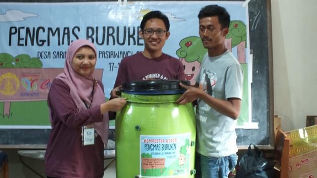 Ketua Tim Pengmas UI Astari Dwiranti dan Direktur Holistika Institute Cecep Ernanto, tengah memberikan drum kepada perwakilan warga, sebagai salah satu media pembuatan pupuk organik