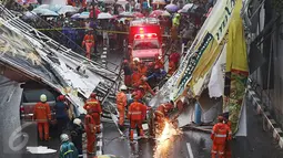 Petugas berusaha memotong bagian JPO yang roboh di Jalan Raya Pasar Minggu, Jakarta Selatan, Sabtu (24/09). Korban meninggal akibat JPO roboh dibawa ke RS Siaga Pasar Minggu. (Liputan6.com/Immanuel Antonius)