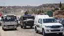 Mobil-mobil pemerintah dan kendaraan militer Rusia melintasi jalan raya utama antara Homs dan Hama di Suriah, Rabu (6/6). Pembukaan jalan itu dilakukan sebulan setelah pasukan Suriah merebut kembali wilayah kantong yang dikuasai militan itu (AFP/STRINGER)