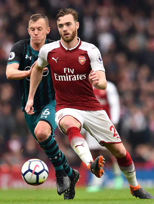 Pemain Arsenal Calum Chambers mengendalikan bola dibayangi gelandang Southampton James Ward-Prowse dalam lanjutan Premier League 2017/2018 di Stadion Emirates, Minggu (8/4). Arsenal menang tipis dengan skor 3-2 atas Southampton. (Glyn KIRK / AFP)