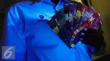 Petugas menunjukan uang kertas rupiah yang disinari lampu ultraviolet saat peruri media visit di Perusahaan Umum Percetakan Uang Indonesia (Peruri), Karawang, Jawa Barat, Rabu (18/1). (Liputan6.com/Faizal Fanani)