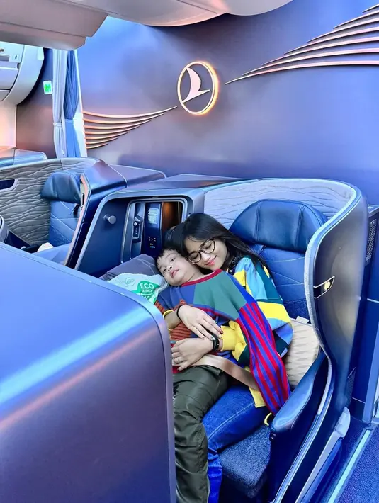 Saat berada di pesawat menuju Turkiye, Fuji dan Gala kompak tampil dengan sweater warna-warni yang nyaman. [@fuji_an]