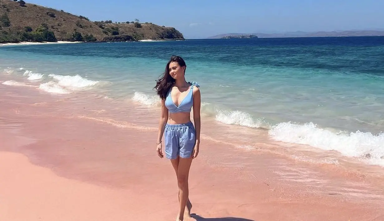 Berada di pink beach, Gege mengenakan atasan bikini biru dipadukan celana pendek warna serasi dan membiarkan rambutnya terurai. Credit: @gegeelisa94