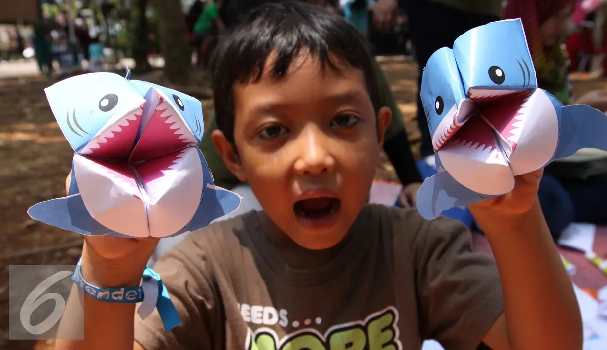 Seorang anak memperlihatkan karya ikan hiu dalam festival laut 2015 di taman Kridaloka,  Senayan, Jakarta, Sabtu (19/9/2015). Festival bertujuan untuk mengenalkan dunia laut Indonesia kepada masyarakat serta untuk menjaganya. (Liputan6.com/Angga Yuniar)