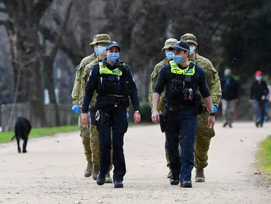 Petugas kepolisian dan tentara berpatroli di jalur lari yang populer di Melbourne, Selasa (4/8/2020). Negara bagian Victoria di Australia, khususnya ibu kota Melbourne mengumumkan status darurat bencana COVID-19 pada Minggu (2/8) waktu setempat. (William WEST / AFP)