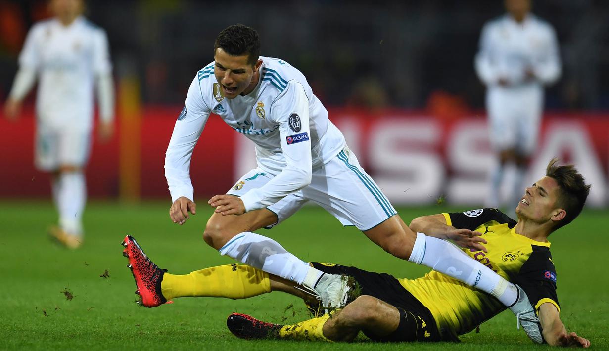 Bintang Real Madrid, Cristiano Ronaldo, dijatuhkan bek Dortmund, Lukasz Piszczek, pada laga Liga Champions di Stadion Signal Iduna Park, Dortmund, Selasa (26/9/2017). Dortmund kalah 1-3 dari Madrid. (AFP/Patrik Stollarz)