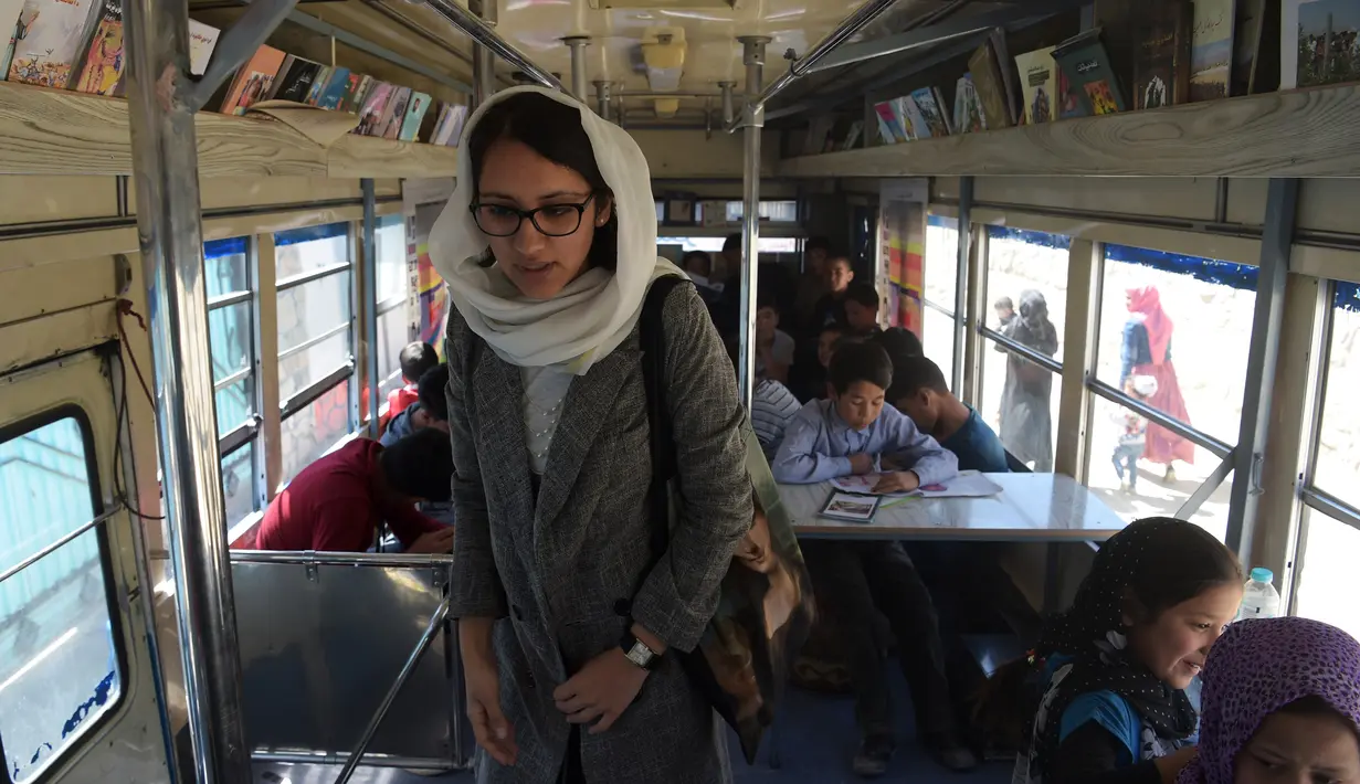Freshta Karim berada di dalam bus yang dijadikan perpustakaan keliling di Kabul, 4 April 2018. Ide untuk membuat perpustakaan adalah karena pengalaman masa kecil Freshta yang tidak memiliki kesempatan untuk mengunjungi perpustakaan. (AFP/Shah MARAI)