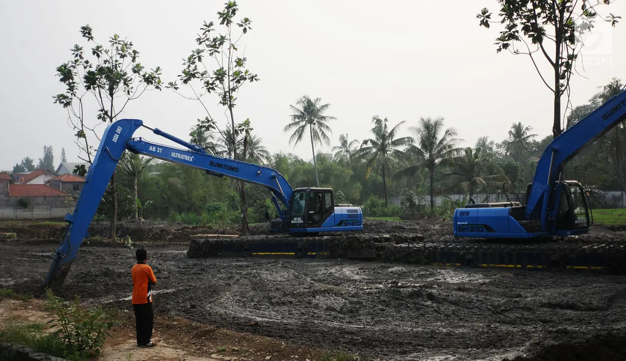 Petugas mengawasi proses pengerukan di hulu Setu Babakan, Jakarta, Jumat (7/7). Menurut petugas, air sengaja disurutkan terkait proyek pengerukan di sekitar hulu Setu Babakan. (Liputan6.com/Helmi Fithriansyah)