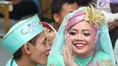Pasangan nikah massal bercanda usai ijab kabul di jalan MH Thamrin, Jakarta, Senin (31/12). 557 pasangan mengikuti nikah massal dan isbat nikah pada malam pergantian tahun 2018-2019. (Liputan6.com/Helmi Fithriansyah)