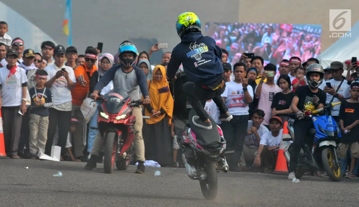 Warga menyaksikan atraksi freestyle sepeda motor saat memeriahkan Festival Damai Millenial Road Safety di Monas, Jakarta, Minggu (23/6/2019). Festival ini juga dimeriahkan oleh berbagai atraksi dan pertunjukan musik artis Tanah Air. (merdeka.com/Iqbal Nugroho)
