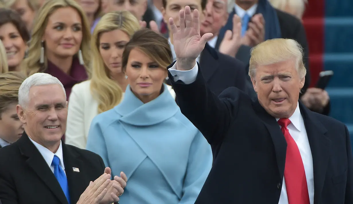 Donald Trump melambaikan tangan jelang menyampaikan pidato pertamanya sebagai Presiden AS di Capitol Hill, Washington DC, AS, Jumat (20/1). Dikabarkan, Trump sendiri yang menulis dan menyusun pidato pelantikannya. (AFP Photo)