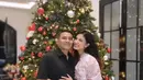 Judika dan Duma Riris merayakan Natal di rumahnya. Judika mengenakan kemeja hitam serasi dengan celananya. Duma mengenakan dress pink bermotif. [@jud1ka]