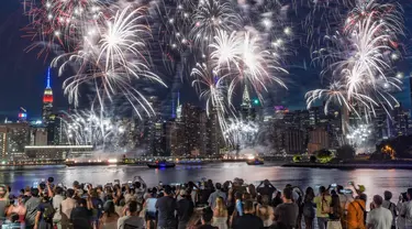 Penonton berkumpul di sepanjang tepi pantai Williamsburg untuk menyaksikan pertunjukan kembang api Macy pada perayaan Hari Kemerdekaan di Brooklyn, New York, Amerika Serikat, 4 Juli 2022. Kembang api meledak dari tongkang di East River. (AP Photo/Bebeto Matthews)