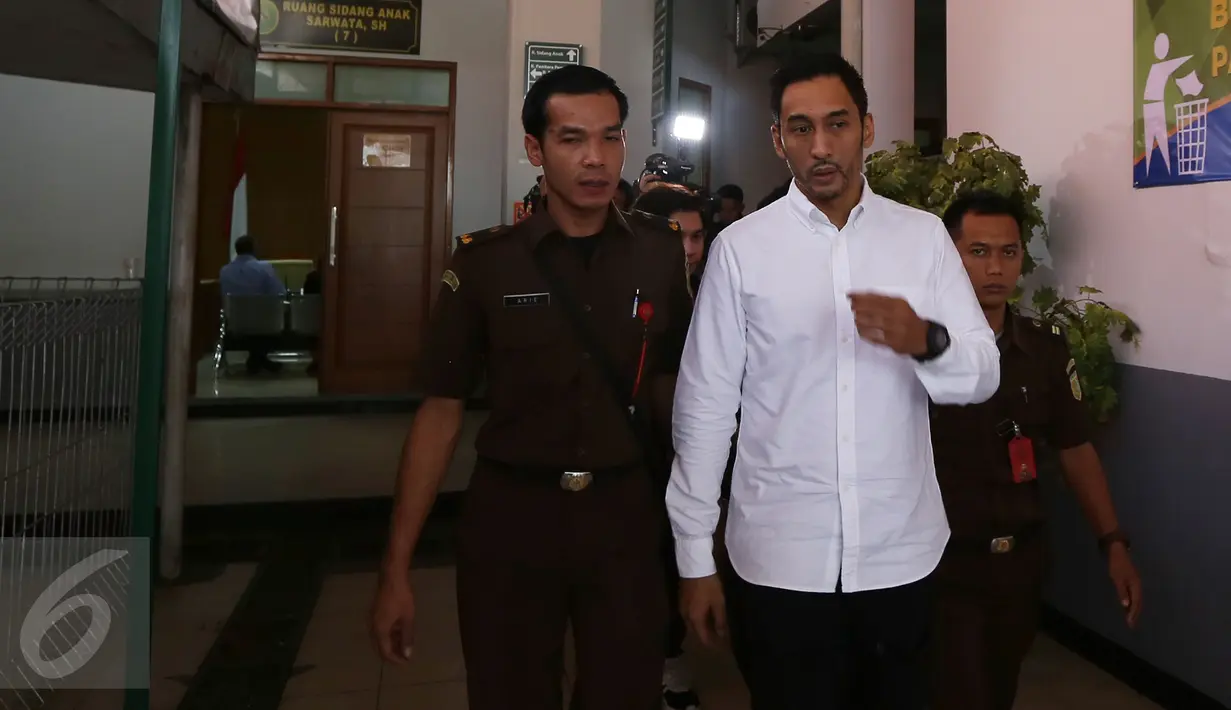 Aktor Restu Sinaga dikawal petugas meninggalkan PN Jakarta Selatan, Selasa (20/12). Majelis Hakim menunda sidang pembacaan putusan kasus narkotika Restu Sinaga lantaran salah satu Hakim Anggota berhalangan hadir. (Liputan6.com/Herman Zakharia)