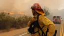 Petugas pemadam kebakaran melihat api yang membakar kawasan sebelah Otay Lakes Road di dekat Highway 94, California, Amerika Serikat, Sabtu (20/5). Kebakaran tersebut melahap lahan seluas 1000 hektar. (AP Photo/Hayne Palmour IV)