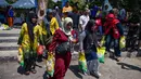 Warga membawa beras usai mengantre membeli kebutuhan pokok di salah satu pasar di Surabaya, Jawa Timur pada Selasa 23 September 2025. (Juni KRISWANTO/AFP)