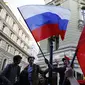 Suporter Rusia mengibarkan bendera menyambut gelaran Piala Dunia di Jalan Nikolskava, Moskow, Rabu (13/6/2018). Piala Dunia 2018 akan berlangsung pada 14 Juni hingga 15 Juli mendatang. (AP/Rebecca Blackwell)