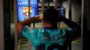 Suporter memgang kepala saat mengikuti protes di depan kantor Barcelona, Selasa (25/8/2020). Aksi tersebut merupakan respon fans atas kabar Lionel Messi yang akan meninggalkan Camp Nou pada musim panas ini. (AFP/Pau Barrena)
