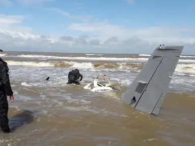 Dua tentara mengecek sisa-sisa pesawat kecil Cessna yang jatuh di wilayah Honduras Honduras La Mosquitia di laut Karibia (18/12). Pesawat itu jatuh di pantai di desa Uhumbila. (Photo by HO/Honduran Armed Forces/AFP)