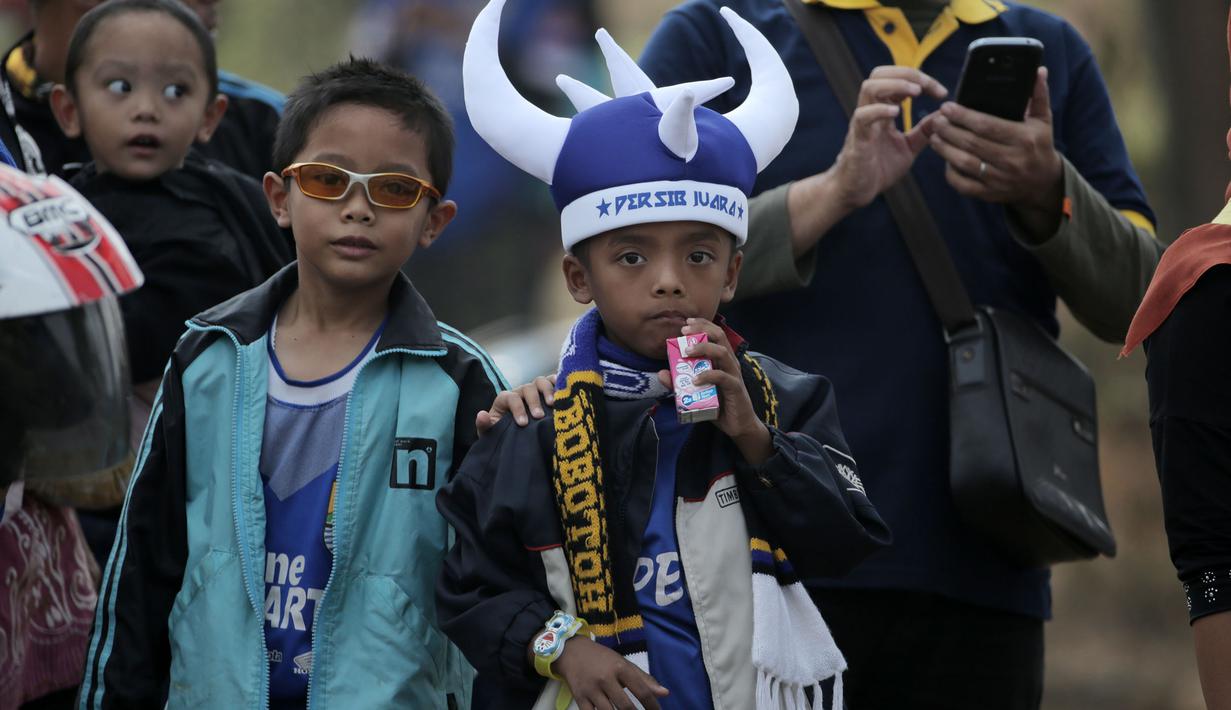 Anak-anak ditemani orang tua hadir dalam acara parade Persib Bandung Juara Piala Presiden 2015 di Kota Baru, Bandung, Minggu (25/10/2015). (Bola.com / Nicklas Hanoatubun)