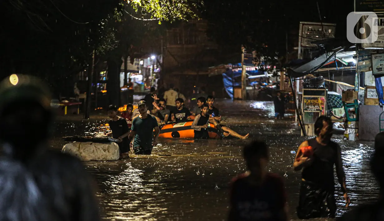 Sejumlah warga melintasi genangan banjir di kawasan Kemang, Jakarta, Selasa (4/10/2022). Jalan Kemang Utara IX tak bisa dilalui oleh kendaraan. Banjir menggenangi kawasan Pasar Kambing dan sejumlah rumah penduduk. (Liputan6.com/Faizal Fanani)