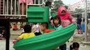 Anak-anak bermain seluncur di Lapangan Banteng, Jakarta, Minggu (14/10). Lapangan Banteng yang dahulu sepi sekarang menjadi tempat favorit warga untuk mengajak anaknya bermain. (Liputan6.com/JohanTallo)