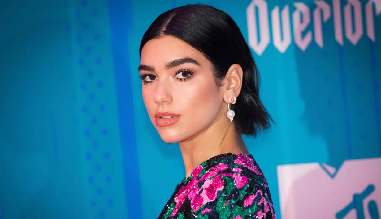 Penyanyi cantik Dua Lipa berpose saat tiba menghadiri MTV Europe Music Awards 2018  di Bilbao, Spanyol (4/11).  Penyanyi asal Inggris tampil cantik dan seksi mengenakan mini dress bermotif bunga di acara tersebut.  (AP Photo/Vianney Le Caer)