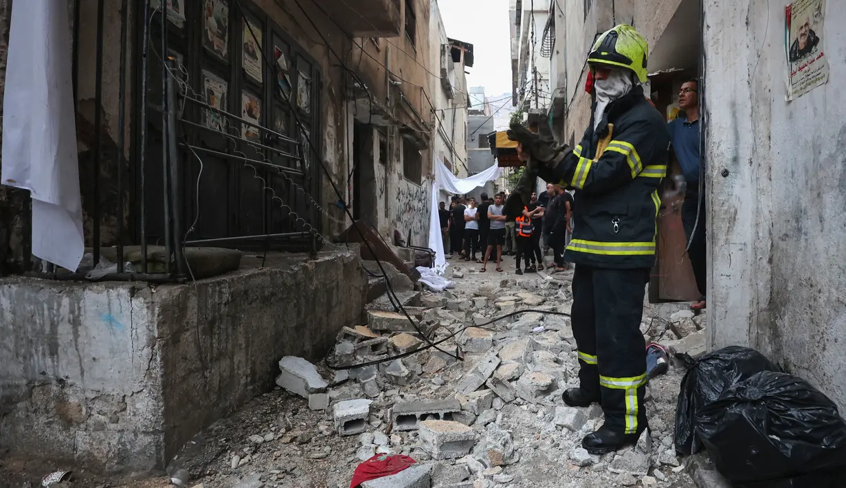 Personil dan penduduk darurat Palestina memeriksa kerusakan setelah serangan pasukan Israel di kamp pengungsi Balata di pinggiran Nablus di Tepi Barat yang diduduki pada awal 16 Agustus 2023. (AFP/Zain Jaafar)