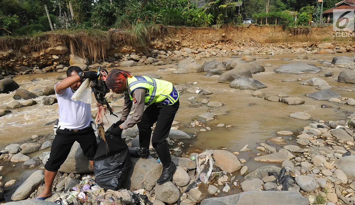 Dua Anggota Polantas Polres Bogor memungut sampah saat kegiatan aksi bersih sungai di kawasan aliran Sungai Ciliwung, gadog, Bogor (20/9). Aksi bersih sungai dalam rangka HUT lalu lintas ke-63. (Merdeka.com/Arie Basuki)